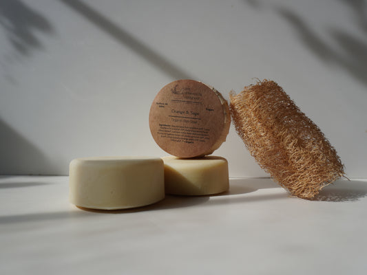 Three natural skincare products on a white surface with a neutral background